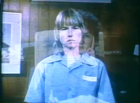 The still from the 'Love Child' trailer features a young girl with a serious expression, wearing a blue shirt. The background is a wooden wall, adding a nostalgic feel typical of 16mm film. There's a ghostly overlay suggesting another image, hinting at themes of memory or duality. The visual quality reflects the grain and characteristics of vintage film stock.