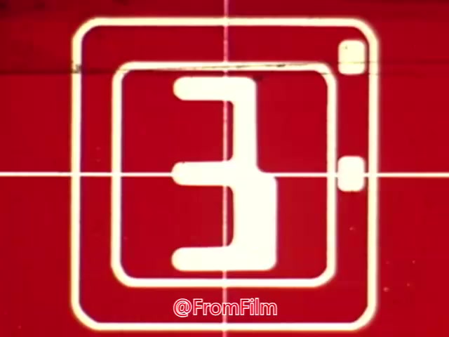 The still appears to be a frame from a vintage film featuring a countdown animation. It shows the number '3' prominently against a red background, possibly indicating the start of a segment or an advertisement related to a coffee break theme. The overall aesthetic suggests it might be from a quirky or experimental animation, typical of mid-20th century promotional materials. The context implies it's likely designed to capture attention in an entertaining way, though the exact purpose or messaging remains unclear.