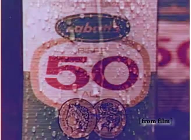 The still features a close-up of a Labatt beer can, prominently displaying the number '50' on a red label. The can is covered in condensation, suggesting it's cold and refreshing. Below the label, there are two small coins illustrated, enhancing the visual appeal. The background has a blurred effect, focusing attention on the can itself. The overall aesthetic reflects the marketing style of the 1970s.