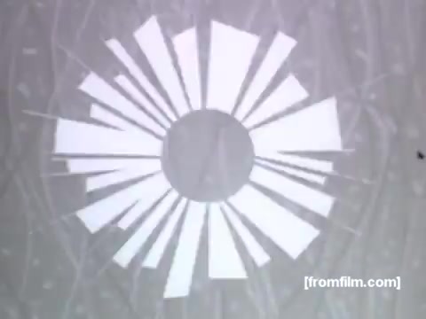 The still from the 16mm UPA animation features a stylized, sunburst design in white against a textured background. The geometric shapes radiate outward from a central circle, conveying a sense of energy and movement. This visual design aligns with the 1950s aesthetic, emphasizing modernity and efficiency, likely reflecting the promotional themes of Caloric Gas Appliances.