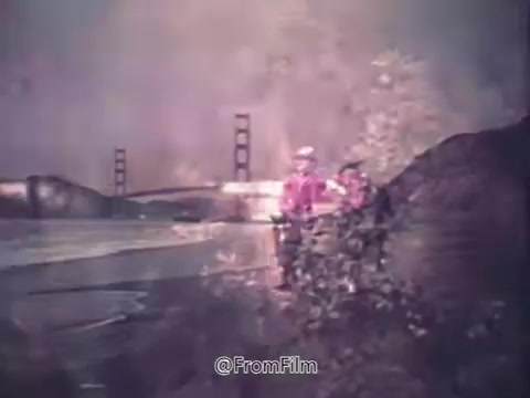 The still from 'Canada Dry Ginger Ale - The Unexpected Soft Drink' features a serene outdoor scene, likely depicting individuals enjoying nature, with a bridge in the background. The colors are soft and slightly faded, typical of 16mm film. The emphasis is on the relaxed ambiance, aligning with the soft drink's refreshing image during the 1970s.