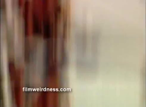 The still from the 'Outlaw Blues' trailer features a blurred image, likely capturing a dynamic moment from the film. The colors suggest a mix of earthy tones, typical of vintage cinema. The overall composition conveys a sense of movement, aligning with the film's themes of rebellion and adventure associated with Peter Fonda's character.