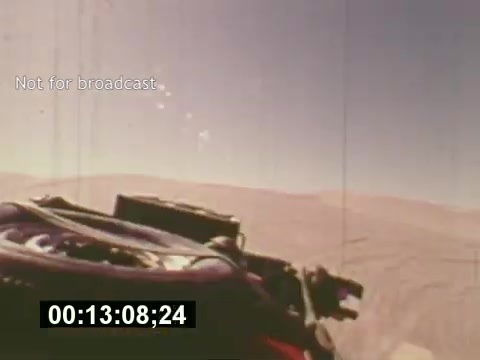 The still from 'Sixty Second Spot' appears to depict a view from a camera mounted on a vehicle or drone, showcasing a vast, arid landscape. The shot likely represents a pivotal moment in the creation of a 7-Up commercial, emphasizing adventurous or aspirational themes. The timestamp indicates the ongoing progress within the film, capturing a behind-the-scenes look at the filming process, from script development to the final product. The note 'Not for broadcast' suggests it is a unique or unpublished segment.