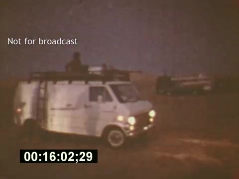 The still from 'Sixty Second Spot' captures a scene from the mid-1970s during the making of a 7-Up commercial. It features a production van parked in a barren landscape, emphasizing the behind-the-scenes aspect of commercial filmmaking. The timestamp indicates it's an early moment in the film, highlighting the preparation stages leading up to the commercial's final presentation. The 'Not for broadcast' label suggests it's an unedited segment meant for internal use.
