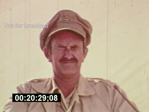 The still from 'Sixty Second Spot' features a man in a military-style hat and a light-colored jacket, squinting with a slight smile, suggesting a humorous or light-hearted moment. The image captures a behind-the-scenes look at the creation of a 7-Up commercial, emphasizing the production process from casting to filming. The timestamp and 'Not for broadcast' label indicate it's a private or unfinished segment, likely focusing on the candid realities of making the advertisement in the mid-1970s.