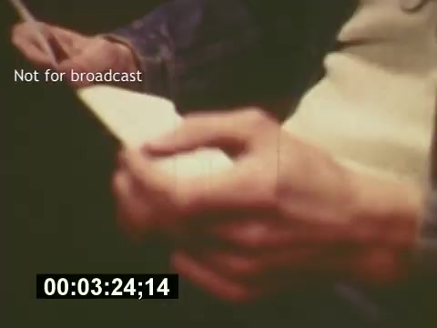 The 16mm still from 'Sixty Second Spot' captures hands engaged in the creative process of making a 7-Up commercial, highlighting aspects like scripting and casting. The image reflects a behind-the-scenes glimpse into the advertising world of the mid-1970s, emphasizing the collaborative effort involved. The timestamp suggests it comes from a specific moment in the film, and the label 'Not for broadcast' indicates it's intended for private viewing.