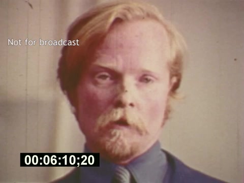 The still from 'Sixty Second Spot' features a close-up of a man with a mustache and long hair, looking directly at the camera. He appears serious, likely reflecting the tone or intent of a commercial being created. The caption 'Not for broadcast' suggests that this is a behind-the-scenes moment, highlighting the creative process of making a 7-Up commercial from the mid-1970s. The timestamp indicates it's a specific moment in the film, offering insight into pre-production aspects like casting and conceptualization.