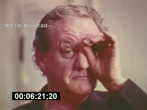 This still from 'Sixty Second Spot' captures a moment during the creation of a 7-Up commercial, showcasing the behind-the-scenes process from script development to casting and filming. The image features an older man with a contemplative expression, indicating the intensity of the creative process. The inclusion of a timecode suggests that this is a still from the editing phase, providing a glimpse into the production journey of the mid-1970s commercial. The film ultimately culminates in the presentation of the finished ad.
