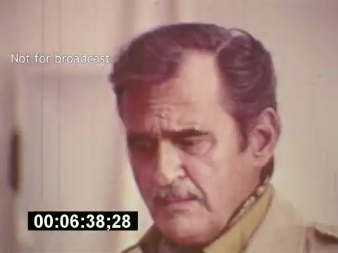 The still from 'Sixty Second Spot' captures a moment during the creation of a 7-Up commercial from the mid-1970s. It features a man with a serious expression, likely an actor or director, reflecting on the script or performance. The film provides insights into the behind-the-scenes process of casting and filming, highlighting the complexity of commercial production. The timestamp indicates a specific point in the narrative, while the 'Not for broadcast' label signifies that this is archival footage.