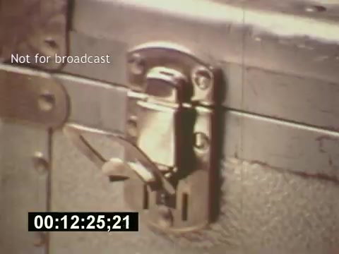 This 16mm still from 'Sixty Second Spot' captures a close-up of a lock on a metal trunk, possibly representing the mystery or anticipation involved in the creative process of producing a 7-Up commercial. The film focuses on the journey from script to casting and filming, culminating in the final commercial. The image emphasizes the behind-the-scenes aspects of advertising in the mid-1970s, highlighting both the craftsmanship and some of the tools of the trade used in the era.