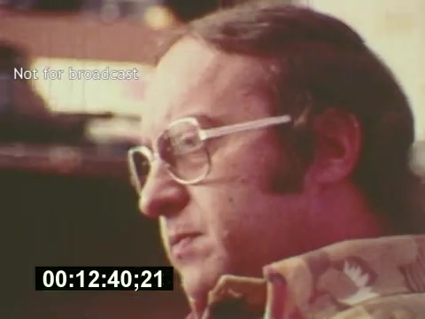 This 16mm still from 'Sixty Second Spot' features a close-up of a man with glasses, deep in thought, likely during a creative session for the 7-Up commercial. The film captures the behind-the-scenes process of creating a TV ad, showcasing elements such as scripting, casting, and filming, with this particular moment hinting at the focus and contemplation involved in the advertising process. The timestamp indicates a specific point in the film, emphasizing its documentary style.