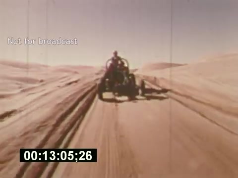The still from 'Sixty Second Spot' captures a moment from the creation of a 7-Up commercial, showcasing a vehicle traversing a sandy landscape. The frame features a driver in a rugged environment, emphasizing the outdoor adventure theme typical of 1970s commercials. A timecode at the bottom indicates the film's progress. The 'Not for broadcast' watermark suggests it's a behind-the-scenes look rather than an official release. This glimpse illustrates the production elements involved in crafting a memorable television advertisement.