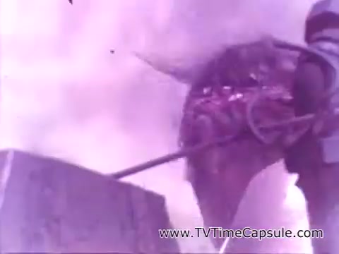 The still appears to depict a scene from the Coca-Cola advertisement 'Have a Coke and a Smile - Coke Adds Life.' It features a figure, possibly in work attire, engaged in an immersive setting with a focus on the action of pouring or manipulating a beverage, amidst a dreamy, atmospheric backdrop characterized by soft colors. The imagery conveys a sense of nostalgia and the emotive connection associated with enjoying a Coca-Cola.