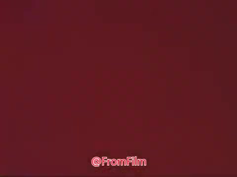 The still features a simple, solid red background. It appears to represent a segment from a public service announcement featuring James Stewart in support of the Civil Air Patrol. The lack of detailed imagery suggests it may be a transitional or title card scene.