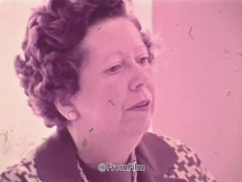 The still from the 1960s PSA features a woman speaking about her experience with vision problems and the need for frequent changes to her glasses. She appears concerned, reflecting on her health issues. The context involves a discussion about eye exams and the discovery of glaucoma, emphasizing the importance of eye health and awareness. The visual tone is soft and slightly faded, typical of the era.