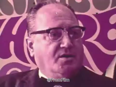 The still from the 'Prevent Blindness PSA' features a man speaking, likely discussing his personal experience with eye health. His expression suggests concern as he shares his journey with glaucoma, following an eye exam that was part of a physical check-up. The context highlights the importance of regular eye examinations and the potential complications of untreated eye conditions, underscoring the PSA's message about maintaining eye health. The colorful background adds a visually engaging element to the serious topic being discussed.