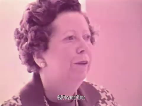 The still from the 'Prevent Blindness PSA' features a woman speaking about her experiences with vision issues and the need for frequent glasses adjustments. The color tone is soft, likely a vintage look typical of the 1960s. Her expression suggests concern as she relates her story, emphasizing the importance of eye health awareness. The surrounding context indicates a discussion about eye exams and medical conditions, highlighting the message of prevention and education in vision care.