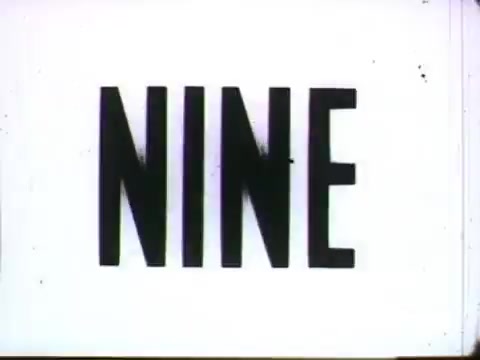 The still features the word 'NINE' prominently displayed in bold, capital letters against a white background. This frame is likely part of a 1958 animated commercial for Bell Telephone, produced by UPA, showcasing an innovative approach to advertising through simple yet striking typography. The vintage aesthetic reflects the era's design trends, emphasizing clarity and visual impact in conveying a message about home communication.