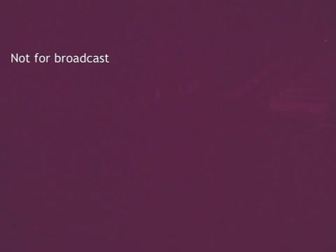 The still from the 'Pruf Spray Starch' commercial features a muted purple background with a watermark stating 'Not for broadcast.' The image suggests a vintage aesthetic typical of 1960s advertisements, likely emphasizing the product's branding without showing specific visuals or characters. The simplicity and color choice may evoke a nostalgic feel associated with mid-20th century marketing.