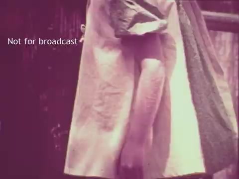 The still features a close-up of a hand holding a garment, highlighting the fabric's texture, possibly showcasing the effects of Pruf Spray Starch. The image appears to have a vintage aesthetic, consistent with a 1960s commercial, and is labeled 'Not for broadcast.' The overall tone suggests an emphasis on laundry care and the product's benefits.