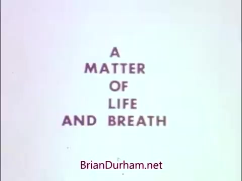 The still features the title 'A Matter of Life and Breath' prominently displayed in a bold, somewhat somber font. This public service announcement from the 1960s or 70s, associated with the National Tuberculosis and Respiratory Disease Association, focuses on respiratory health awareness. James Noble, known for his role in 'Benson,' portrays the 'Sad Commuter,' likely highlighting the struggles and concerns related to respiratory diseases. The overall tone suggests serious themes regarding health and the importance of awareness in preventing respiratory issues.