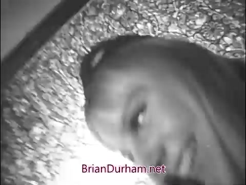 The still is a black and white image from a 1960s Girl Scout commercial. It features a close-up of a girl, likely a scout, smiling or engaging with the camera. The background appears to be textured, possibly creating a whimsical or vintage atmosphere. The overall tone captures the spirit of community and youth typical of that era's advertisements.