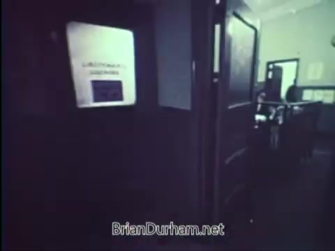 The still from the 1967 PSA by the United States Department of Justice features a hallway with a closed door marked by a sign. The atmosphere suggests a government or office setting. The focus seems to be on promoting car safety, likely emphasizing the importance of locking vehicles. The overall tone conveys a sense of seriousness regarding personal security.