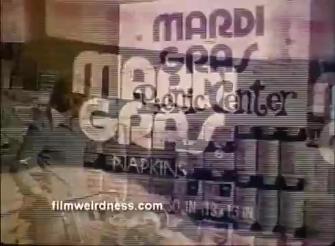 The still features a vintage advertisement for Mardi Gras napkins, showcasing a colorful and playful design typical of the festive theme. It prominently displays the words 'Mardi Gras' along with a mention of a 'Plastic Center.' The background includes an assortment of products, likely related to party supplies, creating a lively atmosphere reflective of the Mardi Gras celebration. The overall aesthetic is reminiscent of retro commercial styles, likely aimed at promoting festive goods in a playful manner.