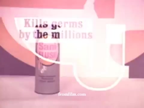 The still features a retro 16mm commercial aesthetic, showcasing a cylindrical can of Sani-Flush prominently labeled with text stating, 'Kills germs by the millions.' The background is vibrant, characteristic of 1970s design, emphasizing cleanliness and germ protection. The overall composition merges product visuals with bold, attention-grabbing typography, typical of marketing strategies from that era.