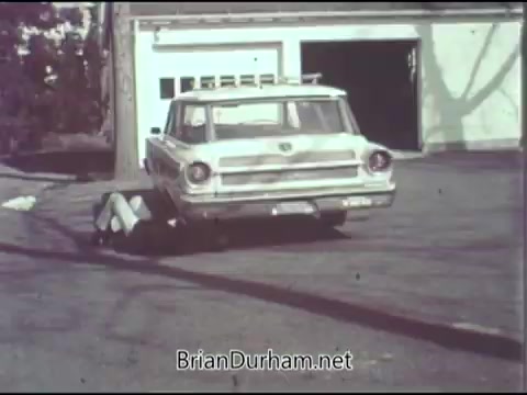 The still from the 1968 'Guideposts PSA' features an older model car, likely from the 1960s, parked in a lot near a building. The car is prominent in the foreground, with a focus on its rear and side. The background shows a garage-like structure and trees. The image has a vintage aesthetic typical of that era's film quality.