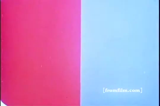 The still from the 1970s Kellogg's Corn Flakes commercial features a split screen with vibrant red on the left and soft blue on the right. The background is minimalistic, drawing attention to the color contrast. The 16mm print style adds a vintage feel, characteristic of advertisements from that era.