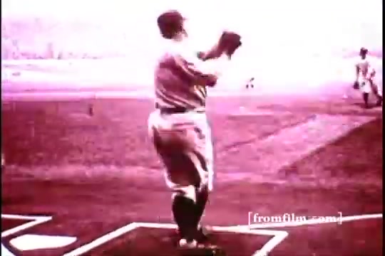 The still from the 16mm print features a baseball scene featuring Babe Ruth, capturing him in a moment of action on the field. The image has a vintage, slightly faded appearance typical of 1970s film, with a monochromatic color scheme. Ruth is poised, possibly preparing to pitch or throw, conveying a classic sports atmosphere, with players visible in the background.