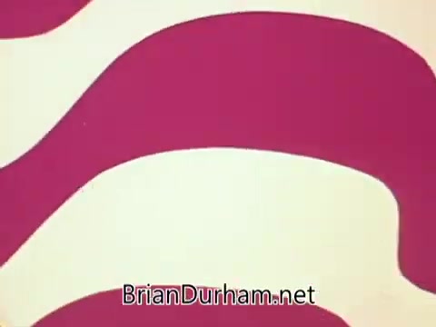 The still features vibrant, abstract shapes in bold colors, primarily pink and cream. The design exhibits a wavy pattern that conveys a sense of movement and energy, typical of the 1970s aesthetic. The bottom of the image includes the text 'BrianDurham.net,' likely indicating the source or creator associated with the content. This visual style is representative of the era's promotional materials, aimed at attracting attention and engaging viewers.