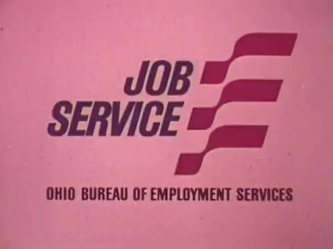 The still features a simple and bold graphic design. It displays the text 'JOB SERVICE' prominently in the center, accompanied by a stylized logo with red and white elements. Below, it includes the phrase 'OHIO BUREAU OF EMPLOYMENT SERVICES.' The background is a soft pink color, creating a contrast with the text and logo. The overall look is representative of 1970s design aesthetics, aimed at promoting employment services in Ohio.