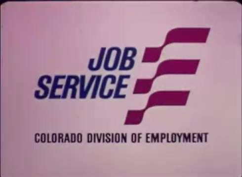 The still features the logo of 'Job Service,' prominently displayed in blue and red against a light background. Below the logo, it mentions 'COLORADO DIVISION OF EMPLOYMENT.' The design reflects a straightforward, professional aesthetic typical of public service commercials, emphasizing the program's purpose of assisting with job placements and openings.
