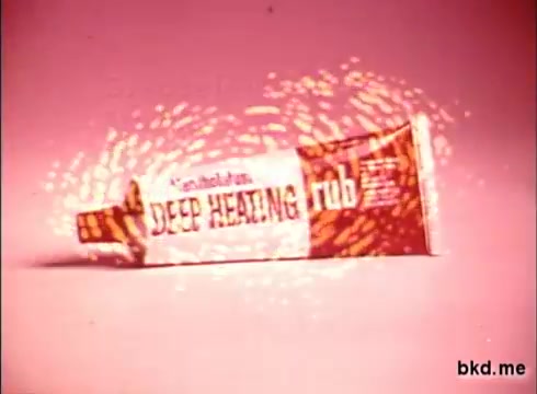 The still features a tube of Mentholatum's 'Deep Heating Rub,' highlighted against a soft pink background. The packaging is vibrant, showcasing bold lettering. Surrounding the product, swirling animated effects create a sense of energy and warmth, emphasizing its soothing qualities. The overall aesthetic is nostalgic, characteristic of 1970s commercial design.