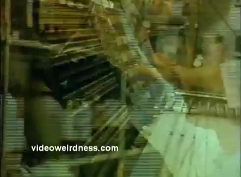 The still from the 'Sandoz Pharmaceuticals/Colors and Chemicals Commercial' features a close-up of laboratory equipment, with a focus on a technician interacting with machinery. The image conveys a sense of scientific precision and innovation, likely aimed at emphasizing the role of Sandoz in pharmaceutical and chemical research. The muted colors and graininess typical of 16mm film lend a vintage quality to the visual, enhancing its educational and informative purpose for the Science Screen Report.