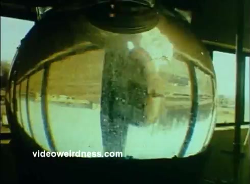 The still features a large, shiny sphere reflecting its surroundings, likely within a laboratory or manufacturing environment related to Sandoz Pharmaceuticals. The amber hued tint suggests a retro color treatment common in older film formats. The distorted reflection hints at scientific processes or experimental setups, emphasizing the fusion of science and technology in the production of pharmaceuticals and chemicals. The overall aesthetic aligns with educational themes intended for classroom use.