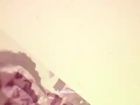 The still from 'Philishave: Xmas (Brazillian)' showcases a warm, nostalgic aesthetic typical of the 1970s. The image features soft, muted colors with a focus on a partially obscured scene, creating an abstract yet suggestive atmosphere. The composition hints at festive themes, possibly involving holiday decorations or a cozy setting, evoking a sense of reminiscence associated with Christmas celebrations of that era.