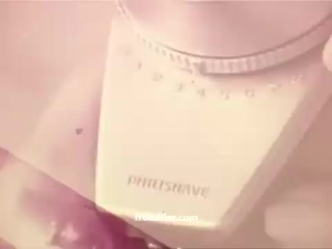 The still from 'Philishave: Xmas (Brazilian)' features a close-up of a Philishave electric shaver, showcasing its design and brand name prominently. The image has a soft, vintage aesthetic, indicative of the 1970s, likely with warm color tones that evoke a nostalgic atmosphere. The background appears blurred, focusing attention on the shaver, emphasizing its significance in the context of the advertisement.