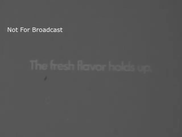 The still is a monochromatic image from a Maxwell House Coffee commercial. It features the text 'The fresh flavor holds up' prominently displayed. The words suggest a focus on the quality and reliability of the coffee's taste. Additionally, there is a 'Not For Broadcast' watermark in the corner, indicating that the image is not intended for public airing.