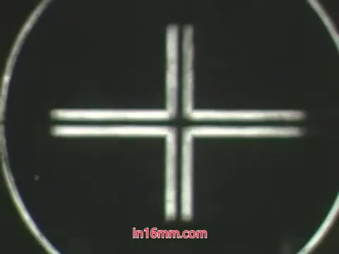 The still from the 'Kukla and Ollie' pesticide PSA features a simple graphic design that resembles a cross within a circular frame, likely used as a visual element for the presentation. In the context of the dialogue, it suggests a focus on the consequences of using harmful pesticides, emphasized by Ollie's distress over his dying plant after using a 'bug bomb.' The puppetry style typical of the 1960s adds a nostalgic and educational tone to the message about responsible gardening practices.