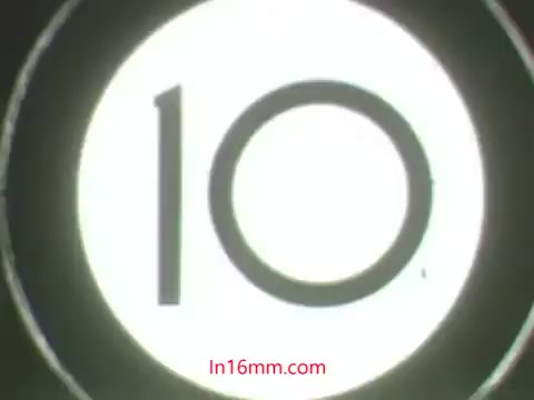 The still features a circular countdown, marking the transition or beginning of a scene, likely from a 16mm film. The number '10' is prominently displayed in the center. The context of the scene involves Ollie, a puppet, lamenting over a dead plant he mistakenly treated with a pesticide, while Kukla responds to his distress. This exchange highlights the dangers of improper pesticide use in a humorous and educational way typical of 1960s public service announcements.