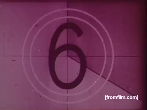 The still shows a countdown graphic from a 16mm film, specifically displaying the number '6' surrounded by concentric circles. The image has a vintage aesthetic, typical of films from the 1970s, with a pinkish tone. This is part of a commercial for the United Fund, showcasing the early days of fundraising efforts, reconstructed from separate audio and visual components, alongside archival film lab paperwork.