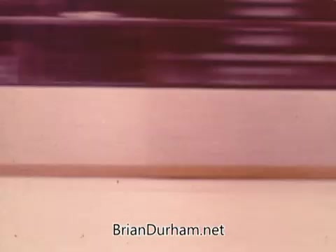 The still from the 1973 NBC NHL Bumper Promo features a blurred motion effect, likely depicting fast-moving images associated with hockey. The color palette is warm with shades of pink and beige, emphasizing speed and excitement. The composition suggests dynamic action, typical of sports promotions, but lacks specific details or identifiable elements.