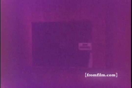 The still from the 1971 Old Milwaukee Beer commercial features a purple-tinted image, making it difficult to discern specific details. This 16mm print likely captures a nostalgic feel, representative of the era's advertising style. The context involves Bernie Kopell, known for his work in television, though his presence in this specific still isn't visually clear.