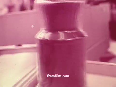 The still from 'Chatham Supermarket Commercials' showcases a close-up of a jar or container, possibly related to food products. The image has a vintage aesthetic typical of 16mm film, with a pinkish hue. It likely emphasizes freshness or quality, aligning with themes from the listed commercial contents like fresh produce and meats. The focus suggests importance on a specific product featured in the supermarket ads.