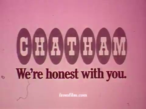 The still features the title 'CHATHAM' prominently with a slogan beneath reading, 'We're honest with you.' The background is a solid pink, giving it a vibrant and inviting feel, suitable for a supermarket commercial. The elements listed, like apples, bananas, and steak, suggest a focus on fresh produce and quality meats, highlighting the supermarket's offerings in a friendly and straightforward manner. The style reflects a vintage advertising aesthetic typical of 16mm film prints.