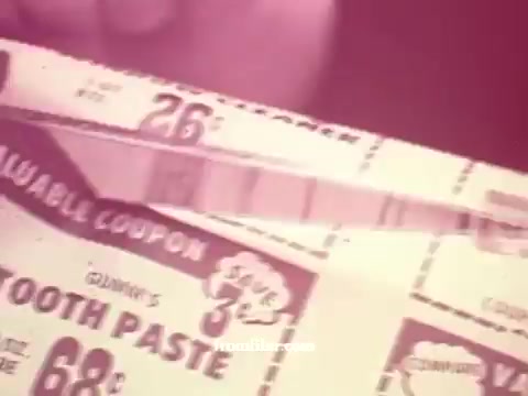 The still from 'Chatham Supermarket Commercials' features a close-up of a coupon. It's likely emphasizing discounts on grocery items, showcasing products like toothpaste, along with a focus on cost-effective shopping. The 16mm film texture gives it a vintage appearance. The visual context indicates a promotional aspect, highlighting deals that may include various produce and meats as part of the supermarket offers.