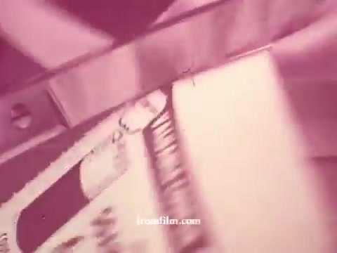 The still from 'Chatham Supermarket Commercials' showcases various grocery items, likely demonstrating promotions or features of the store. Elements include a focus on items such as apples, bananas, and cuts of meat, highlighting the variety available, possibly with visuals of carts and coupons. The overall aesthetic is retro, given it's from 16mm prints, suggesting a nostalgic advertising style.